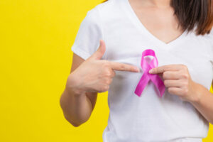 Mulher segurando lanço com a cor rosa da campanha do Outubro rosa