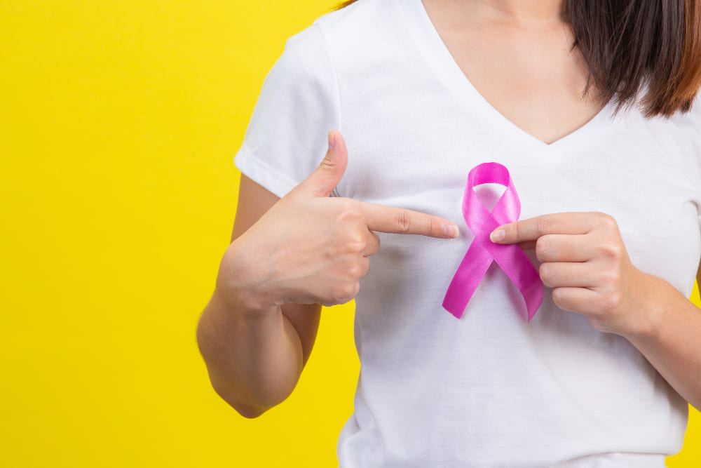 Mulher segurando lanço com a cor rosa da campanha do Outubro rosa