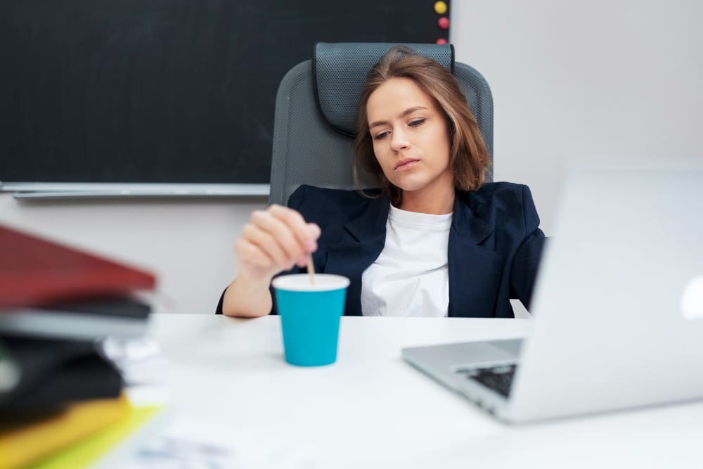 Mulher na frente do computador com dificuldade de se concentrar