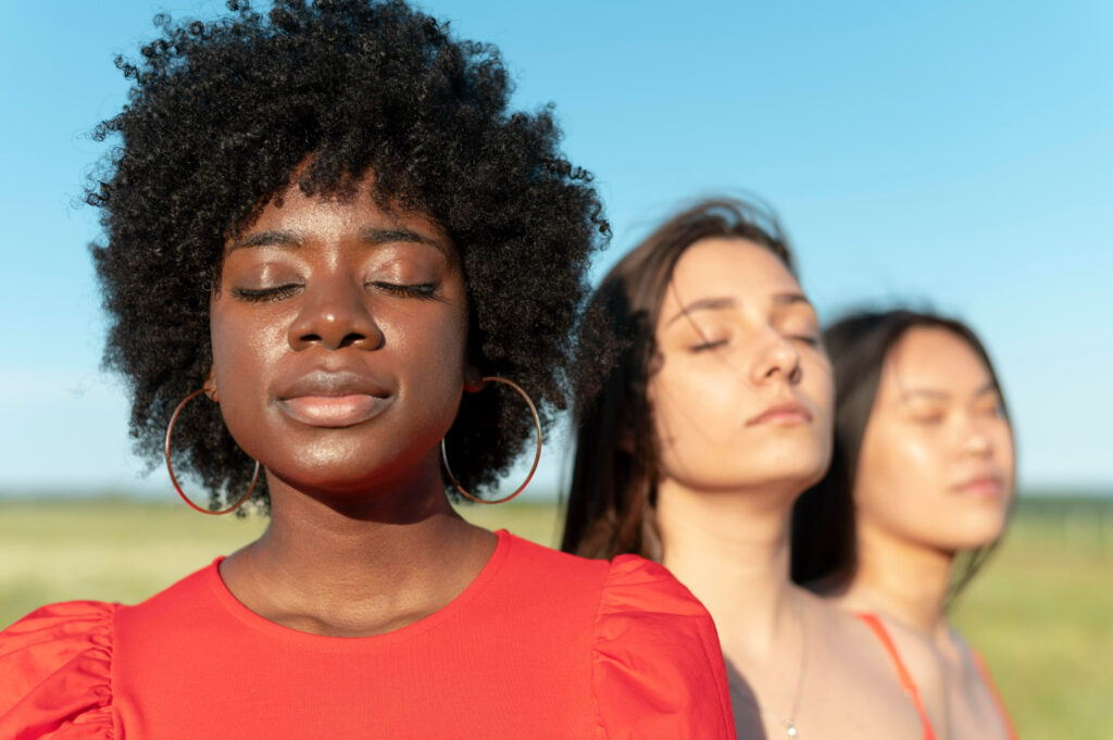 Três mulheres de olhos fechados para representar a importância da saúde mental das mulheres