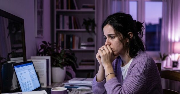 Ansiedade ou Preocupação? Como identificar a diferença 3 Mulher sentada com expressão de preocupação e ansiedade, ilustrando a dúvida entre sentimentos passageiros e sinais de que é preciso buscar ajuda psicológica.